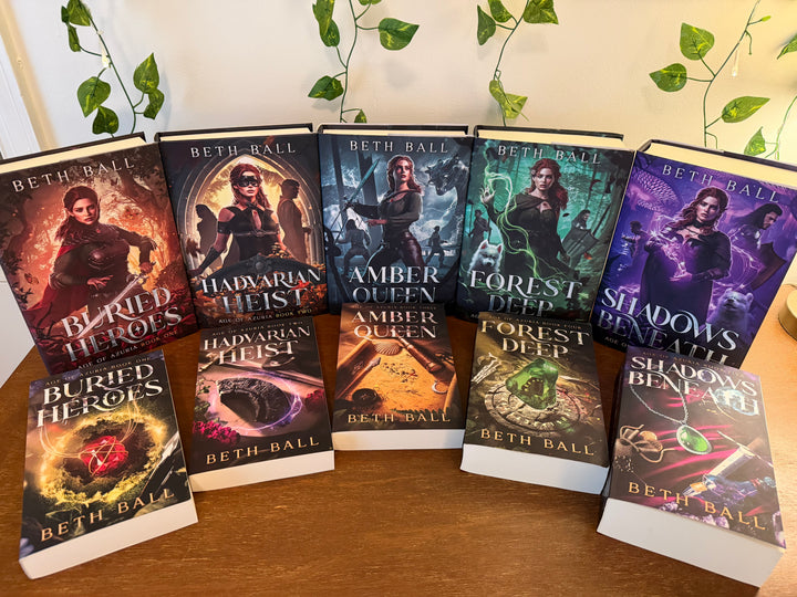 Collection of books by Beth Ball on a wooden surface with plants in the background